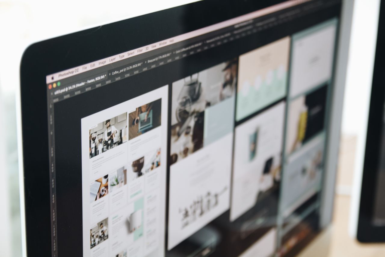 A contemporary computer monitor showing web design projects, highlighting creative visuals in a workspace.